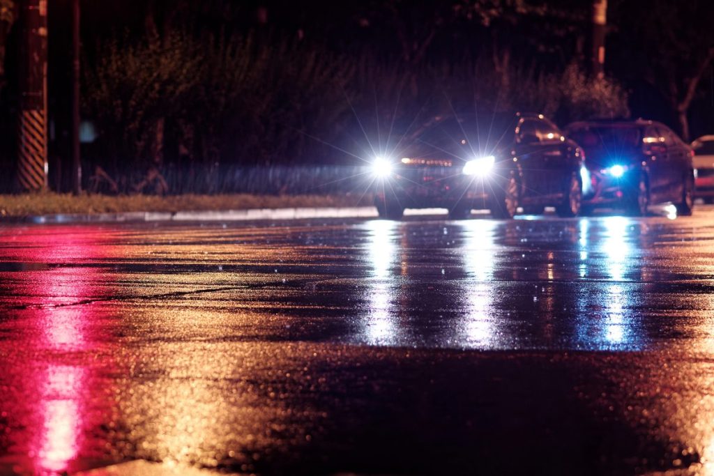 carro iluminando la noche lluviosa