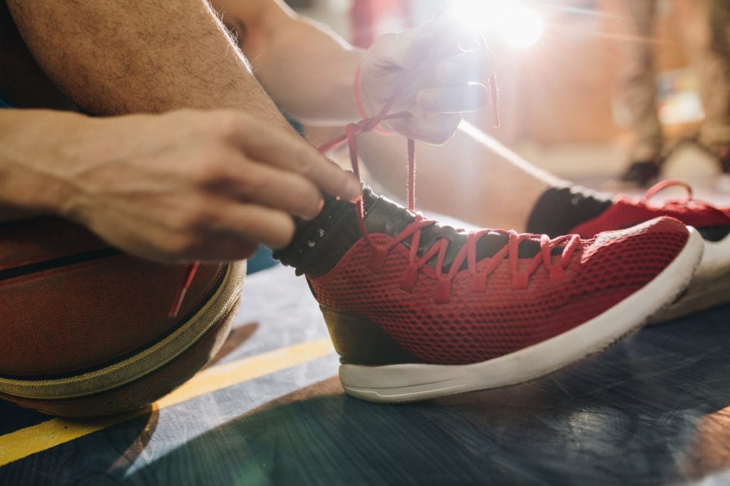 basquetbolista amarrando sus cordones